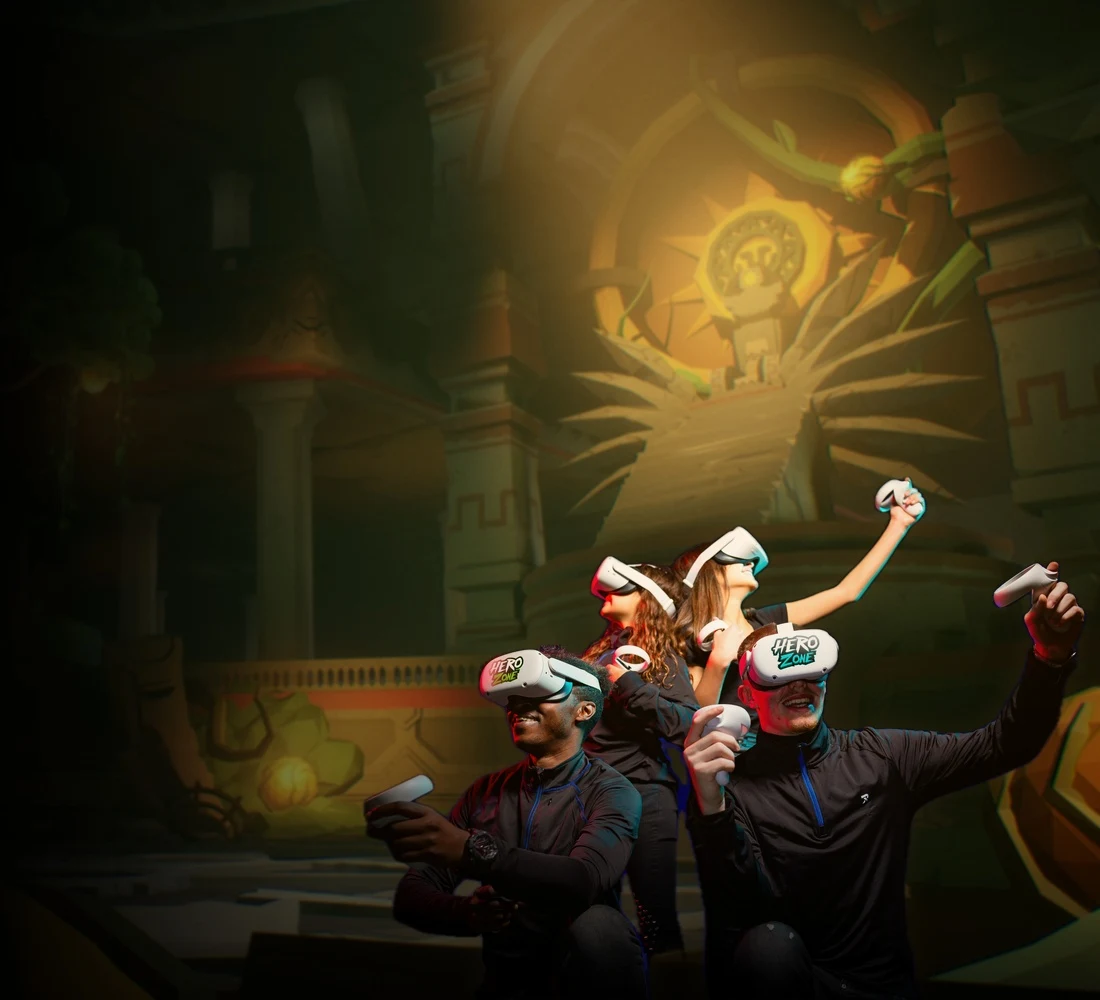 Cuatro personas con visores y mandos VR ante un templo de enigmas.